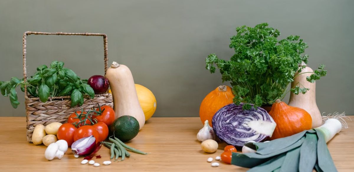 A vibrant assortment of fresh vegetables displayed on a wooden table, perfect for healthy cooking.