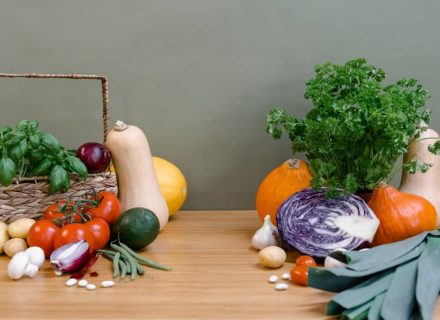 A vibrant assortment of fresh vegetables displayed on a wooden table, perfect for healthy cooking.