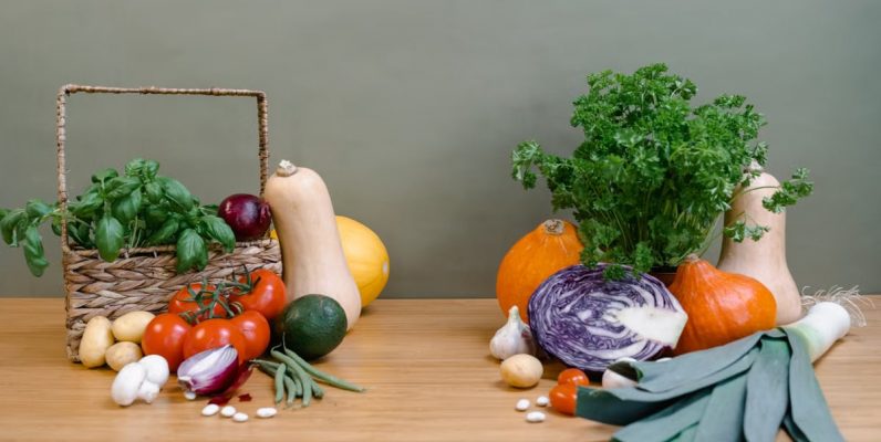 A vibrant assortment of fresh vegetables displayed on a wooden table, perfect for healthy cooking.